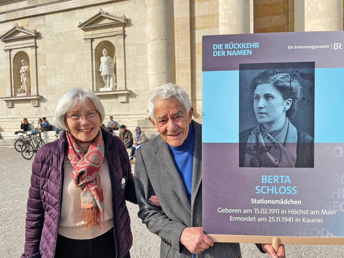 Helga und Michael Wolf mit Plakat von Berta Schloss auf dem Königsplatz