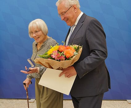 Innenminister Joachim Herrmann begleitet Helga Wolf zurück an ihren Platz