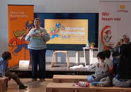 Eine Frau liest einer Gruppe von Kindern vor.